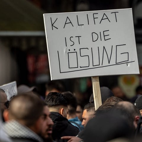 Ein Demonstrant hält ein Plakat mit der Aufschrift: "Kalifat ist die Lösung" (Foto: dpa Bildfunk, picture alliance/dpa | Axel Heimken)