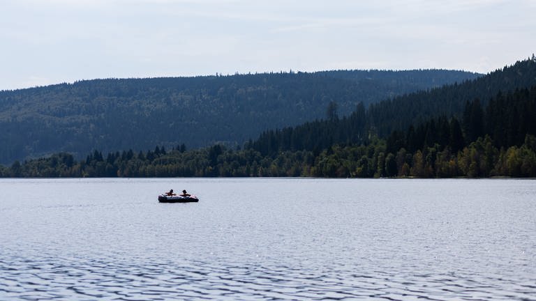Zwei Menschen schwimmen mit einem Schlauchboot auf dem Schluchsee.