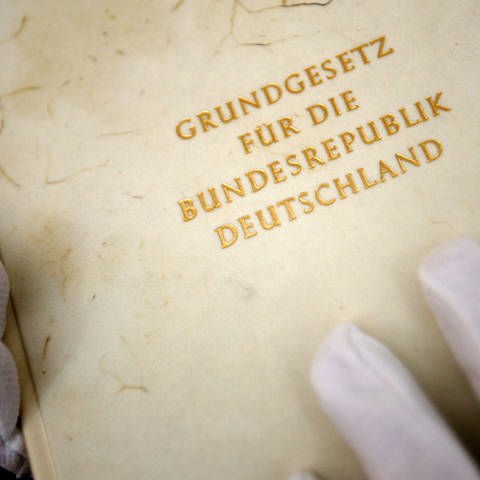 Ein Mitarbeiter zeigt im Haus der Geschichte in Bonn ein Faksimile des Grundgesetzes der Bundesrepublik Deutschland.