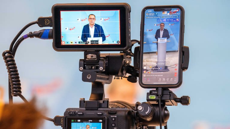 Tino Chrupalla, AfD-Bundesvorsitzender und Fraktionsvorsitzender der AfD, ist auf mehreren Geräten für eine Social Media Übertragung  (Foto: dpa Bildfunk, picture alliance/dpa | Michael Kappeler)