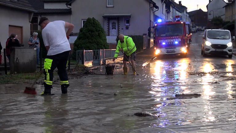 Menschen auf einer überfluteten Straße in Grafschaft (Foto: SWR)