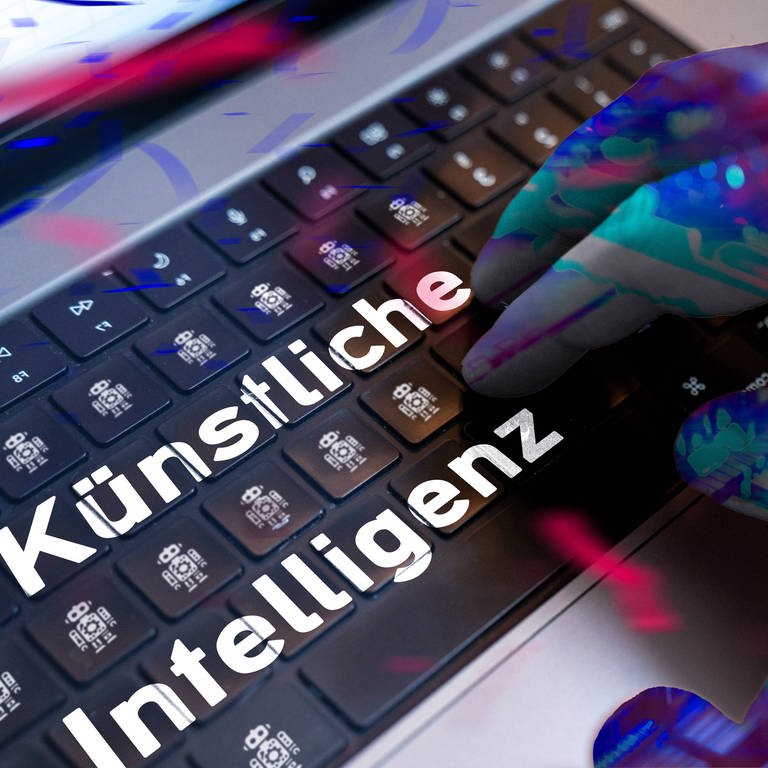 Die Hand eines Roboters liegt auf einer Computer-Tastatur, darauf stehen die Worte "Künstliche Intelligenz": Die Uni Koblenz hat in einer Studie herausgefunden, wie man KI in Zukunft bei Pandemien nutzen kann