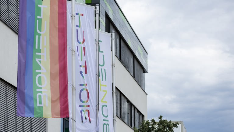 Vor der Zentrale von BioNTech an der Mainzer Goldgrube wehen Fahnen, darunter eine Regenbogenfahne