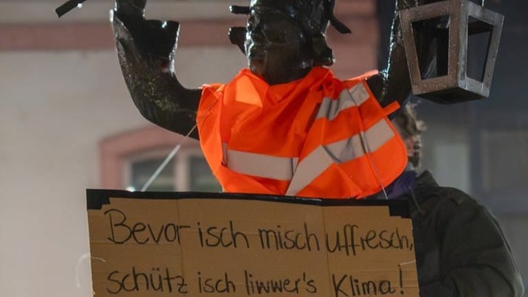 Die Letzte Generation hat in der Nacht zum Weiberdonnerstag bekannte Mainzer Figuren in der Innenstadt mit Warnwesten ud Schildern verkleidet. (Foto: Letzte Generation)