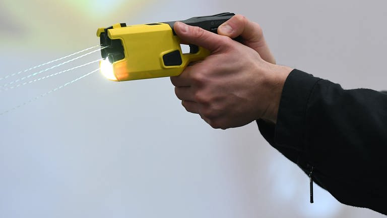 Ein Polizeibeamter demonstriert einen Schuss mit einem Distanzelektroimpulsgerät (DEIG oder auch Taser).  (Foto: dpa Bildfunk, picture alliance/dpa/Revierfoto | Revierfoto)