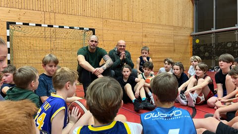 Der Trierer Basketball-Profi Maik Zirbes zu Besuch beim Training eine Jugendmannschaft der MJC Trier. Die Jungen und Mädchen können ihm Fragen stellen. Er ist für viele Trierer Nachwuchtstalente ein großes Vorbild.