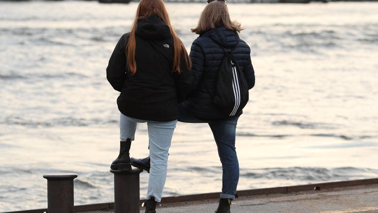 Freundinnen stehen an einer Hafenkante und schauen aufs Wasser (Foto: IMAGO, IMAGO / Hanno Bode)