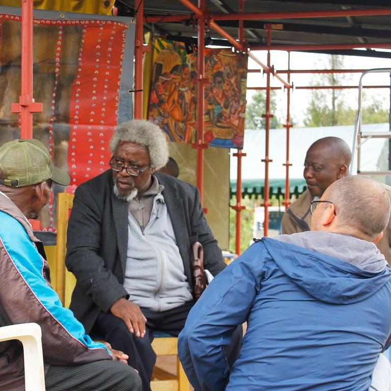Mnyaka Sururu Mboro und Konradin Kunze (von hinten) im Gespräch mit Besuchern der Ausstellung am Kilimandscharo