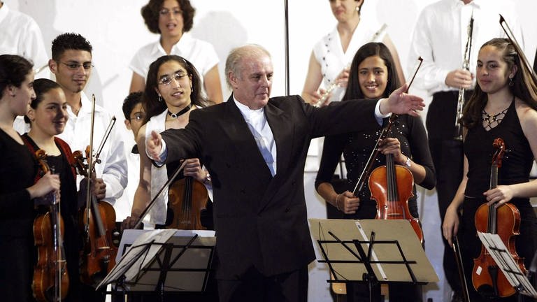 Daniel Barenboim breitet seine Arme aus, um dem palästinensichen Jugendorchester nach seinem Konzert am 7.5.2004 in der Friends School in Ramallah zu gratulieren (Foto: picture-alliance / Reportdienste, dpa/dpaweb | epa Hollander)
