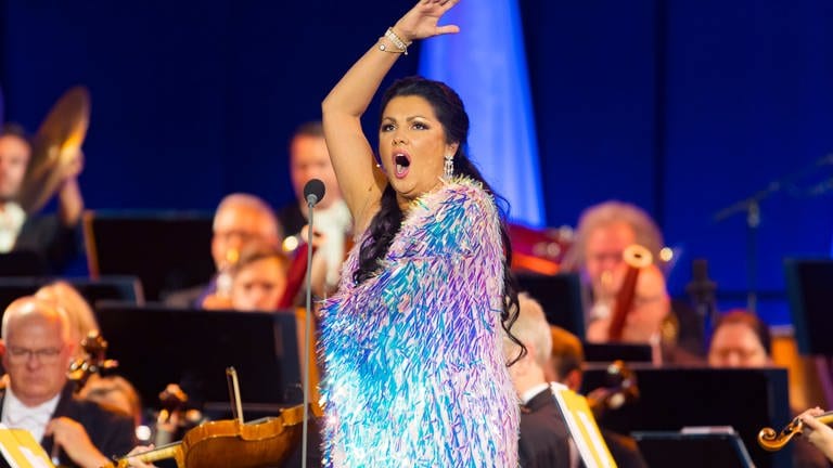 Anna Netrebko singend auf der Bühne. Ihr Kleid schimmert in verschiedenen Blau-Violetttönen (Foto: picture-alliance / Reportdienste, Picture Alliance)