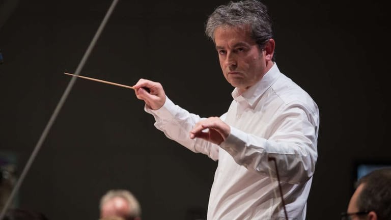 Dirigent probt mit Orchester für das Eröffnungskonzert