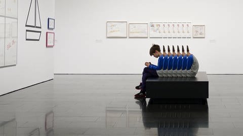 Junge sitzt im Museum