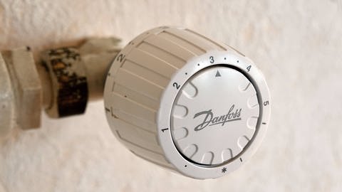 Heizkörperthermostat der Firma Danfoss an einem alten Heizkörper: Danfoss ist auf Wärme- und Kältetechnik spezialisiert und hat 1968 das Thermostat-Ventil erfunden, das heute weltweit an fast jedem Heizkörper zu finden ist. 