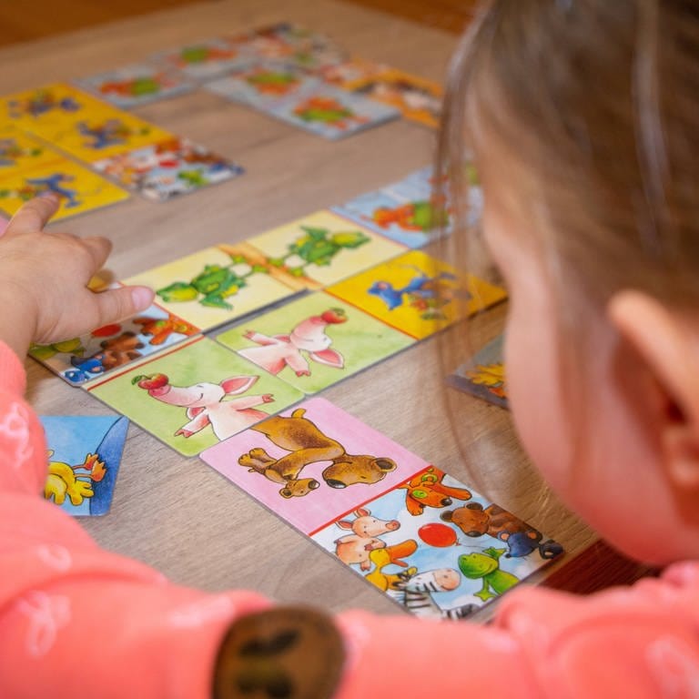 Mädchen spielt mit Bildkarten: Die Sprach-Kitas gelten als sehr erfolgreich, damit kleine Kinder gut Deutsch lernen können. Trotzdem soll das Programm Mitte 2023 auslaufen. Wie geht es weiter mit der Sprachbildung? (Foto: IMAGO, IMAGO / U. J. Alexander)
