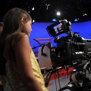 Ein Mädchen steht im Flutlicht-Fernsehstudio vor einer Kamera (Foto: SWR, Ben Pakalski)