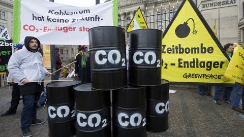 Berliner Demonstration gegen das CCS-Verfahren im Jahr 2011, schwarze Fässer tragen die Aufschrift "CO₂" (Foto: IMAGO, imago/Rolf Zöllner)
