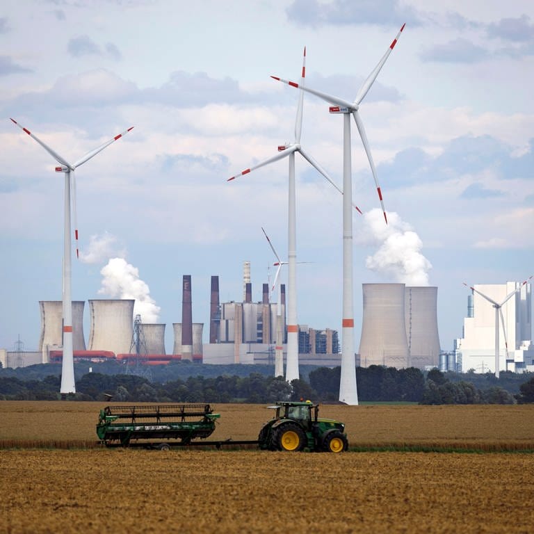 Traktor und Windräder vor einem Kohlekraftwerk - Wie könnte die Wirtschaft in Zukunft aussehen?