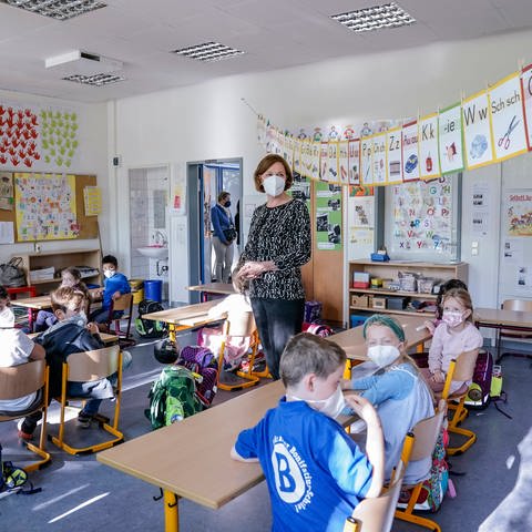 Präsentzunterricht in einer Grundschule. Die Schüler tragen Masken.