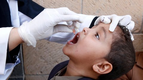 Kind bekommt von medizinischer Fachkraft etwas in den Mund getropft