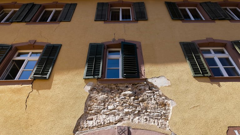 Ein Loch klafft dort, wo an der Wand eines Hauses in der Altstadt von Staufen eigentlich Putz sein sollte.