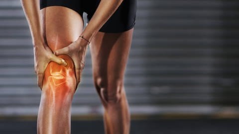 Beim Rückwärtslaufen kann das Knie gleichzeitig trainiert und entlastet werden. Das soll Schmerzen vorbeugen | Illustration schmerzendes Kniegelenk. (Foto: IMAGO, IMAGO / Zoonar)
