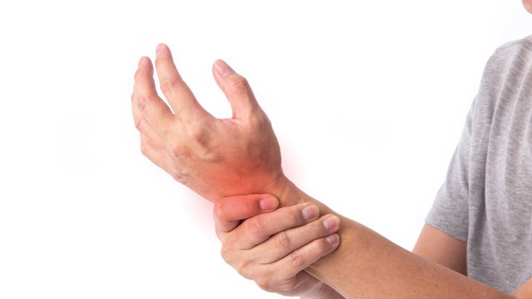 Jemand hält sich das schmerzende Handgelenk, tags: Rheuma, rheumatoide arthritis