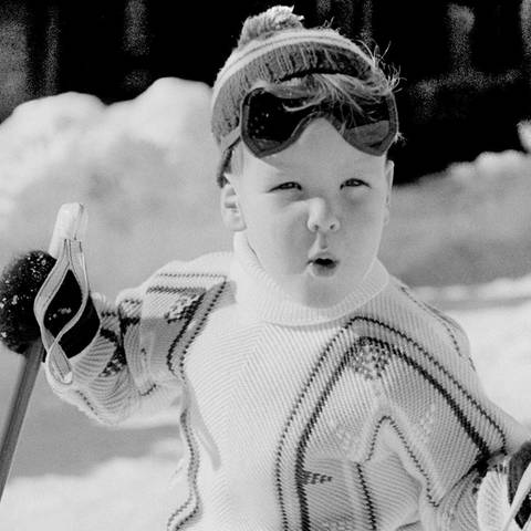 Schwarz-weiß Foto von Fürst Albert von Monaco als Kind bei seiner ersten Ski-Stunde