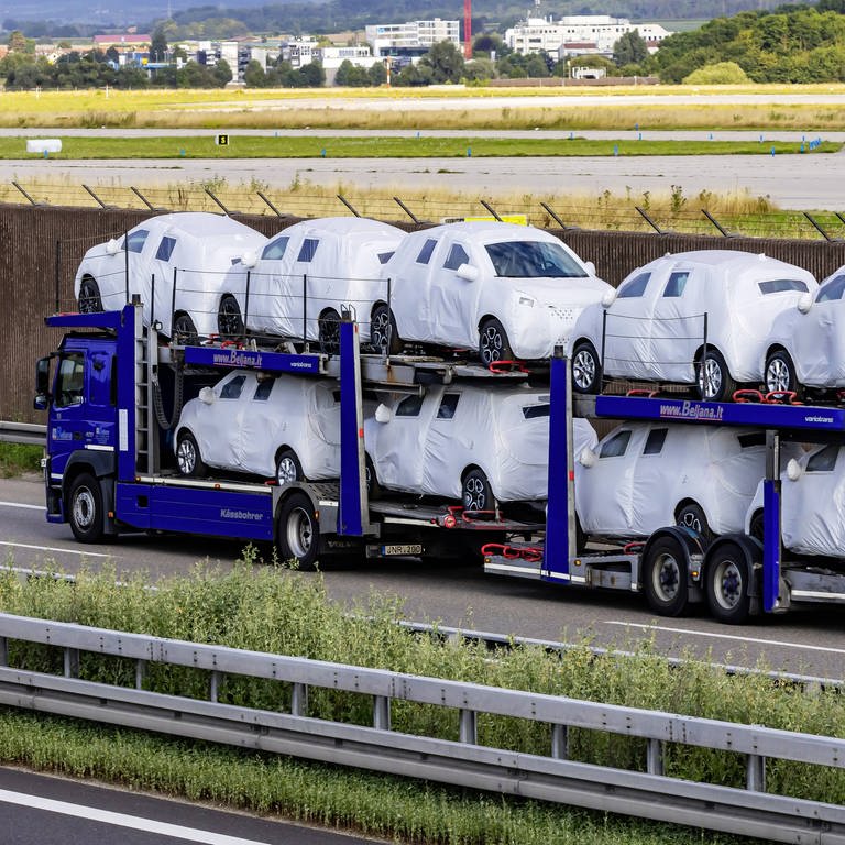 Autotransporter unterwegs auf der Autobahn A8 mit verhüllten Neuwagen