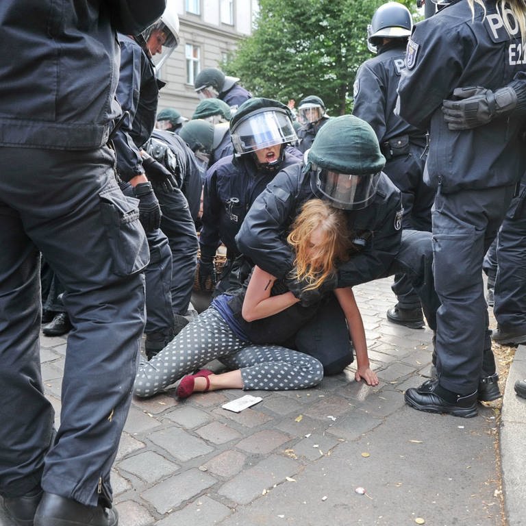 Festnahme einer jungen Frau während einer Protestaktion durch Polizeikräfte