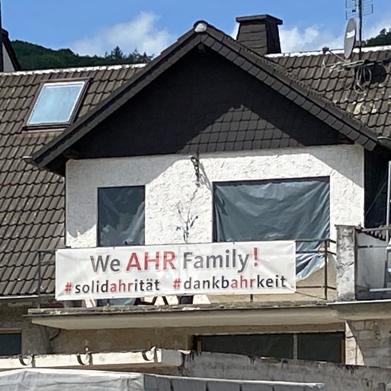 "We AHR Family" steht auf einem Transparent am Balkon eines sich im Aufbau befindenen Hauses