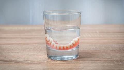 Falsche Zähne in einem Glas. (Foto: Getty Images, Thinkstock -)
