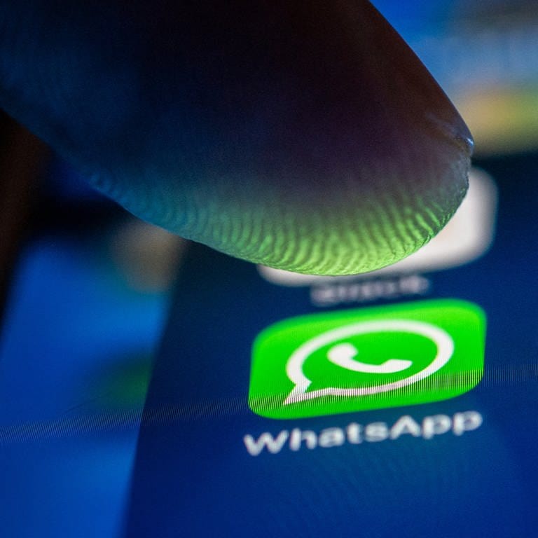 Ein Finger berührt das WhatsApp-Logo auf einem Smartphone. (Foto: dpa)