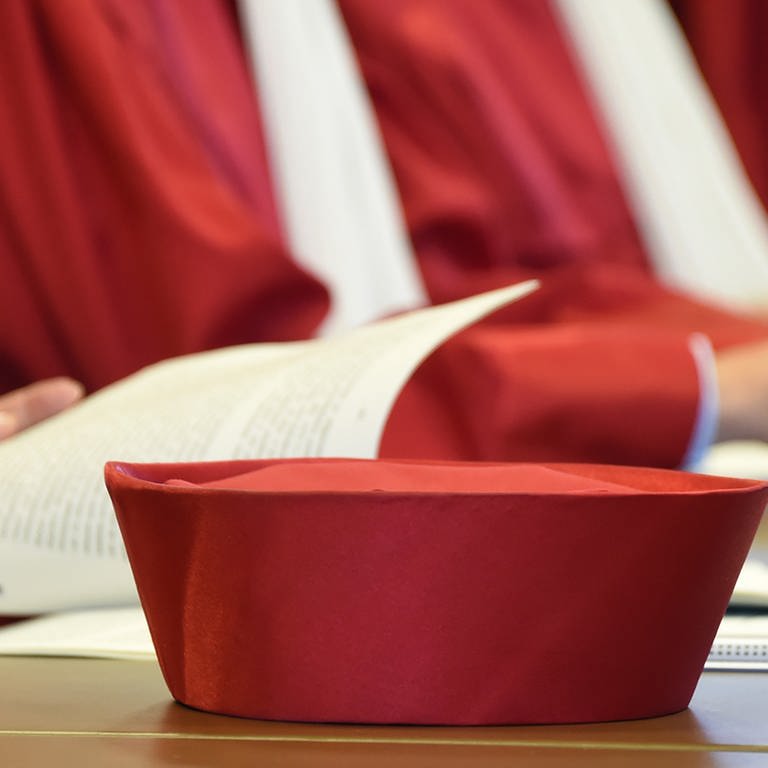 Auf der Richterbank des Zweiten Senats beim Bundesverfassungsgericht in Karlsruhe (Baden-Württemberg) liegt während einer Urteilsverkündung das Barett eines Richters. (Archivbild: 07.10.2014 ) (Foto: picture alliance / dpa)