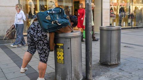 Eine Frau durchsucht einen Mülleimer. ARD Themenwoche WIR GESUCHT - Was hält uns zusammen? (Foto: IMAGO, 0085653826h)