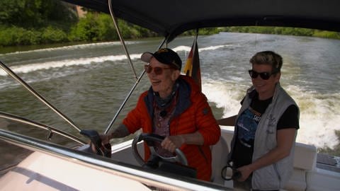Elly und Meike aus Stuttgart fahren zusammen mit einem Motorboot auf dem Neckar und lachen zusammen.