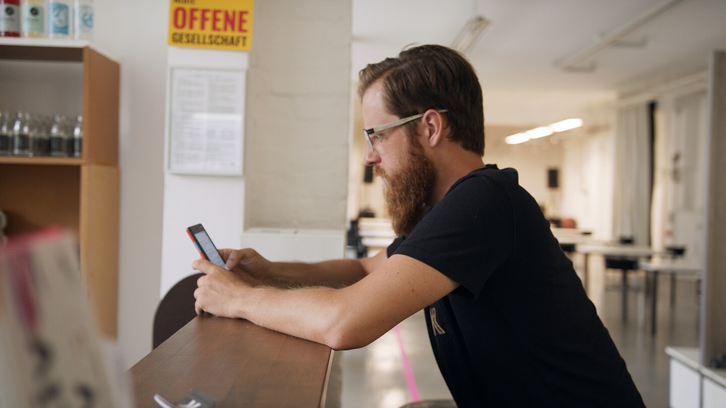 Ein Mann mit Bart schaut auf ein Smartphone (Foto: SWR)