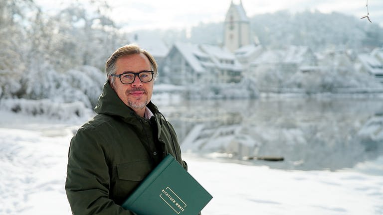 Trauer-Redner Markus steht mit seiner Rednermappe am verschneiten Stadtsee von Bad Waldsee 