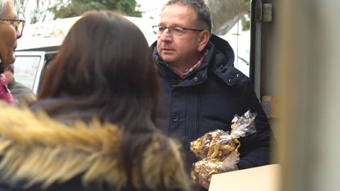 Thomas Knecht, Helfer im Ahrtal verteilt Plätzchen (Foto: SWR)
