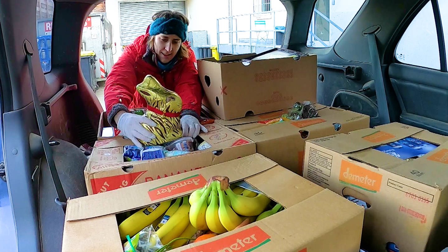 Junge Frau an einem mit Lebensmittelkisten gefüllten Kofferraum (Foto: SWR)