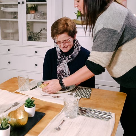 Enkelin Svenja stellt Oma Ursula das Essen auf den Tisch. (Foto: SWR)