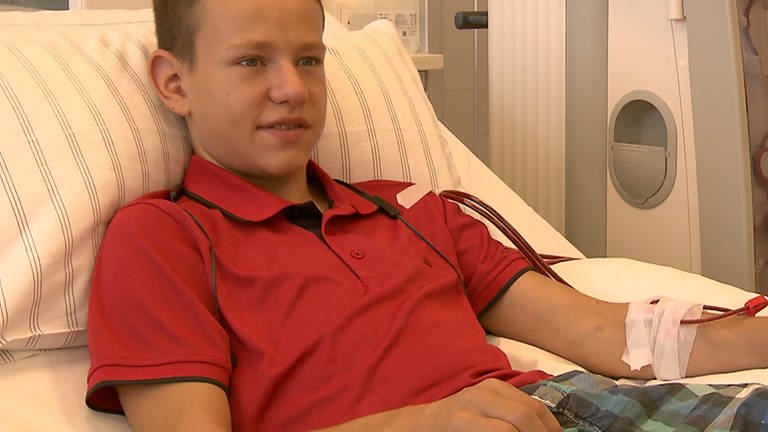 Ein Junge liegt in einem Krankenhausbett bei der Dialyse