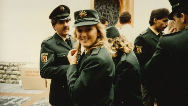 Die junge Claudia Müller steht mit ihren Kollegen zusammen. Alle tragen grüne Polizeiuniformen. (Foto: SWR)