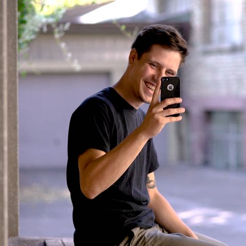 Tomasz lacht und fotografiert mit dem Handy den Kameramann (Foto: SWR)