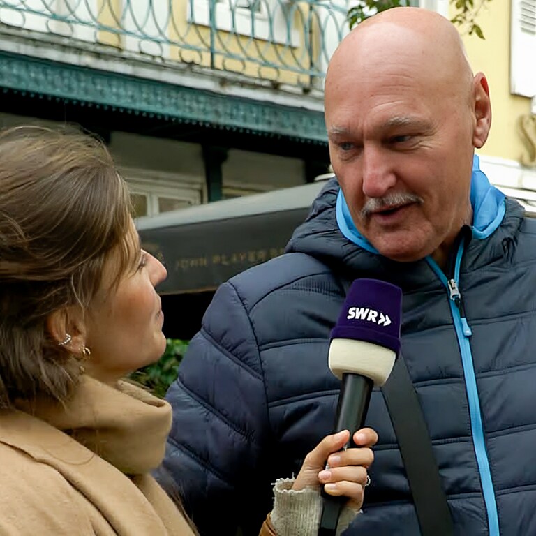 Werner spricht bei der Straßenumfrage in der Karlsruher Innenstadt mit Tici über seine Gefühle und wann er zuletzt geweint hat. Werner hat eine Glatze, ist groß und schaut zu Tici, die ein Mikro in der Hand hält.  (Foto: SWR)