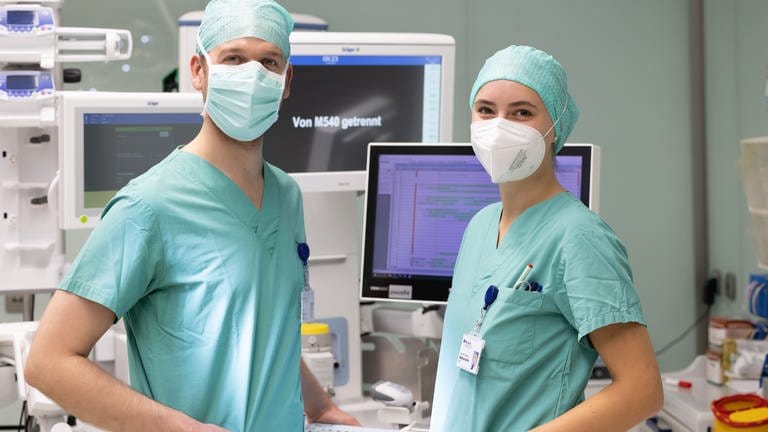 Junge Frau in OP-Kleidung mit einem Kollegen, ebenfalls in OP-Kleidung in einem Operationssaal. (Foto: SWR)