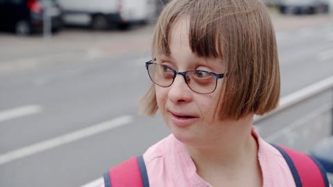 Judith, ein Mädchen mit Down-Syndrom, ist auf der Straße. 
