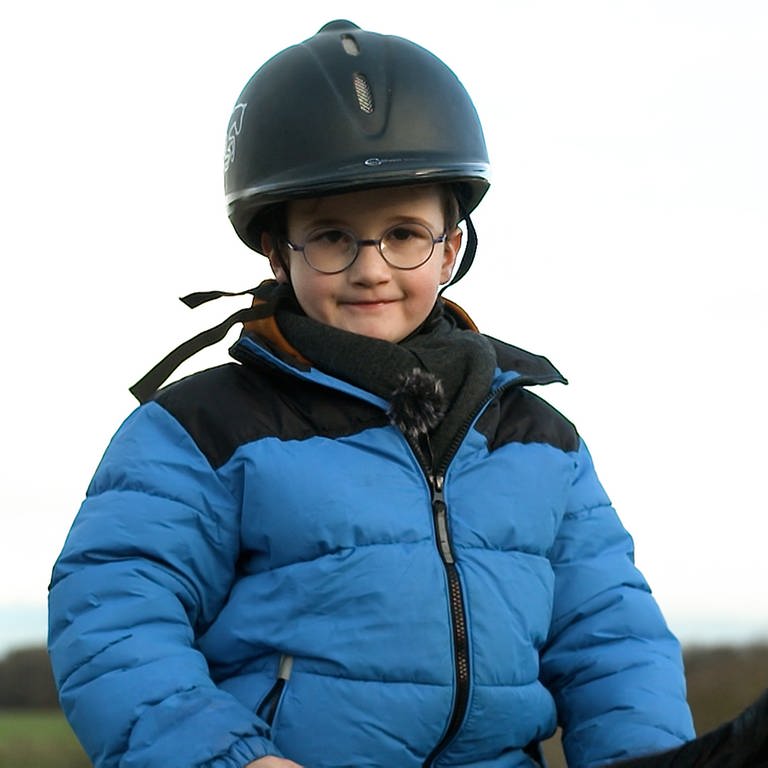 Junge mit Brille in blauer Jacke mit Reiterhelm (Foto: SWR)