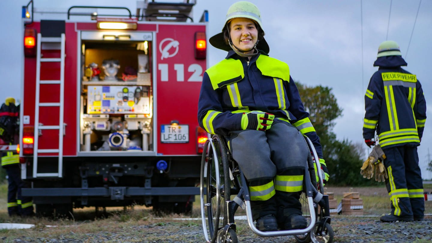 Junge Frau im Rollstuhl vor Feuerwehrauto (Foto: SWR)