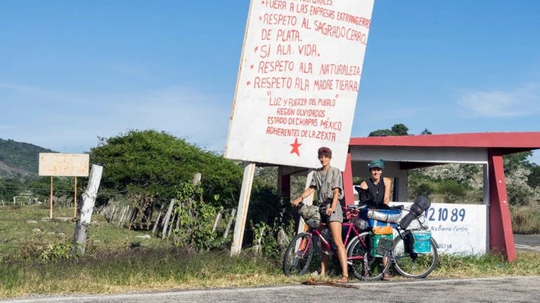 Zwei Frauen mit Fahrrad vor einem Schild an einer Straße. (Foto: SWR)