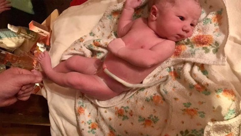 Frischgeborenes Baby liegt noch mit Nabelschnur auf einem geblümten Handtuch. (Foto: SWR)